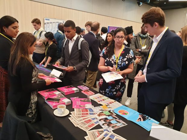 Government Security profession team members speaking to potential recruits at civil service stand