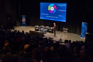 Dominic Fortescue opening address in the auditorium standing on stage